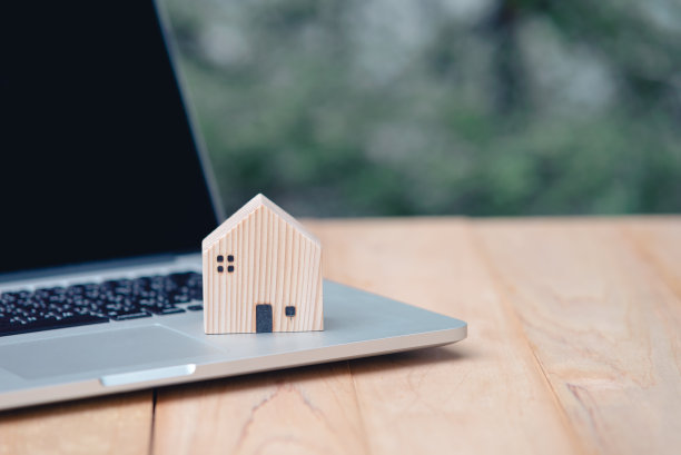 贷款房地产或物业抵押投资概念。房子的木制模型与电脑笔记本电脑在木桌复制空间..图片下载