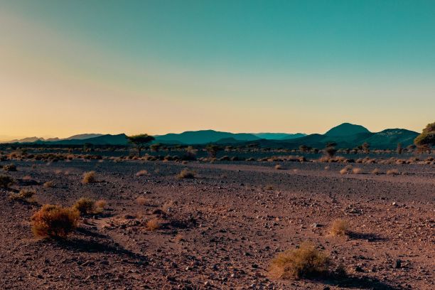 沙漠景观，远处有山，背景是蓝天图片下载