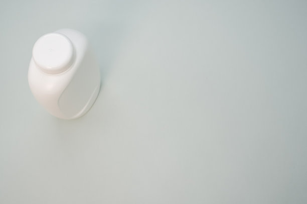 灰色表面上白色空白塑料瓶的高角度拍摄图片下载