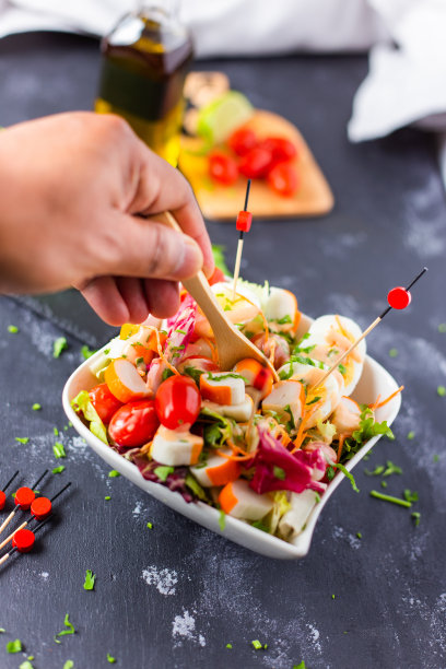 一个人把勺子放在碗里新鲜制作的欧西安沙拉的特写图片下载