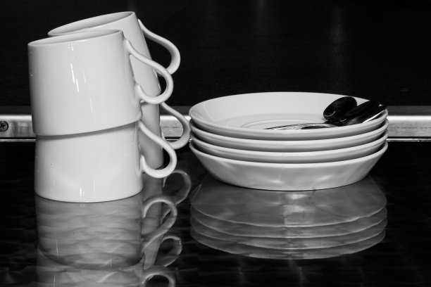 反光的厨房桌子，上面有一堆陶瓷盘子和杯子图片下载