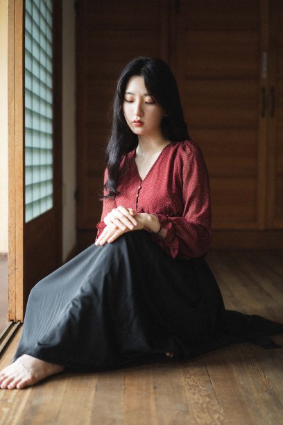 年轻的韩国女人长黑发坐在地板上靠近房间的大窗户图片下载