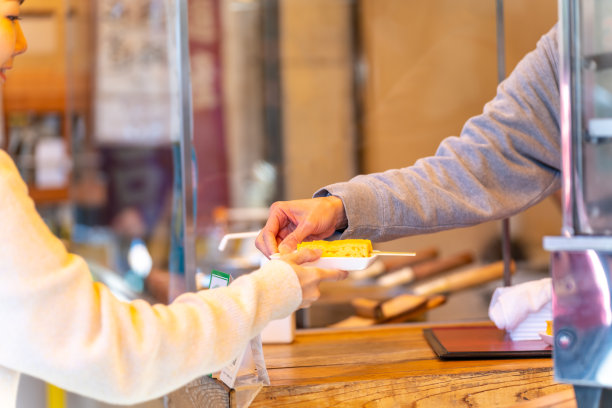日本东京，一名亚洲妇女在街市上买甜蛋卷。图片下载