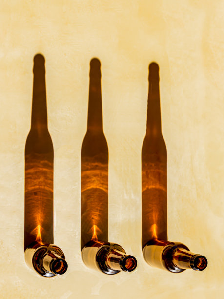 顶部视图的空啤酒瓶与阴影孤立在棕色背景图片下载