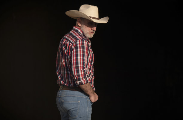 成年男子的肖像在牛仔帽对黑色背景图片下载
