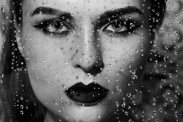 通过湿玻璃捕捉的美丽而感性的女人的肖像图片下载