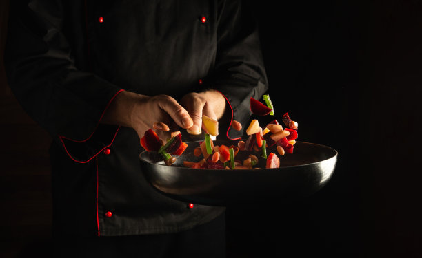 厨师用煎锅烹饪新鲜蔬菜，供素食者食用。饭店或饭店的广告位图片下载