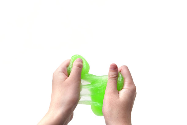 手玩纹理黏液在白色背景。十几岁的手拿着绿色闪亮的粘液与泡沫，伸展粘稠的物质。十几岁的女孩把黏糊糊的玩具挤到一边。液体的玩具。Handgum图片下载