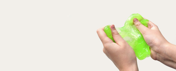 手玩纹理黏液在白色背景。十几岁的手拿着绿色闪亮的粘液与泡沫，伸展粘稠的物质。十几岁的女孩把黏糊糊的玩具挤到一边。液体的玩具。Handgum图片下载