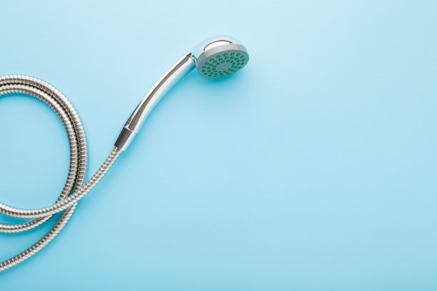 浅蓝色桌子背景上的新淋浴头。柔和的颜色。特写镜头。清洗的概念。文本的空白位置。自顶向下视图。图片下载