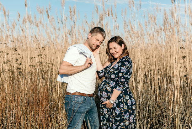 一对年轻漂亮的夫妇要生孩子了。户外照片，快乐的父母在外地。图片下载