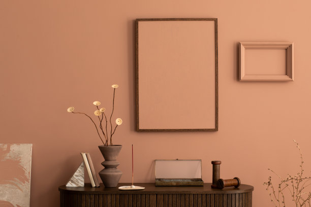 客厅的美学内饰，模拟海报框架，木制马桶，干花花瓶，女人形状的雕塑，粉红色的墙壁，书籍和个人配饰。家居装饰。模板。图片下载