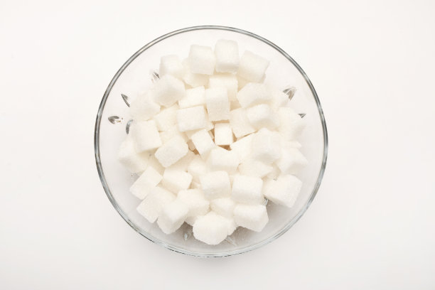 把方糖放在玻璃碗里，放在白色的背景上图片下载