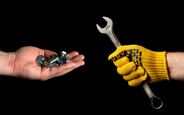 特写人物是手，一个拿着扳手，另一个拿着螺栓和螺母。开始翻新或建造的概念图片下载