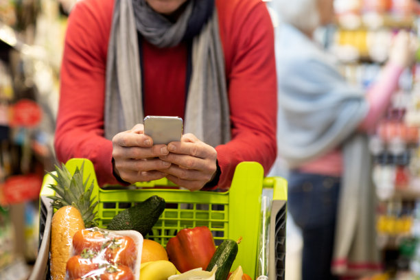 不认识的男子在超市购物时使用手机图片下载