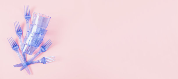 三副蓝色透明塑料眼镜，五把叉子放在粉色背景上。图片下载