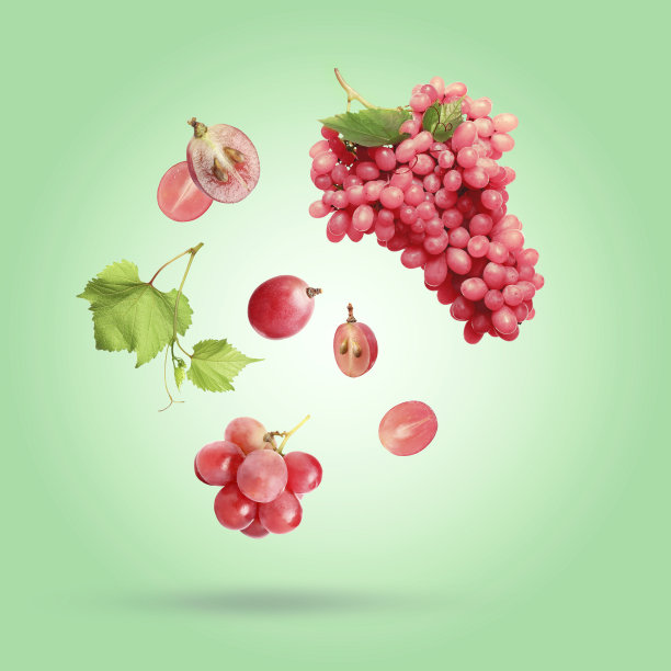 鲜红的葡萄和树叶落在浅绿色的背景上图片下载