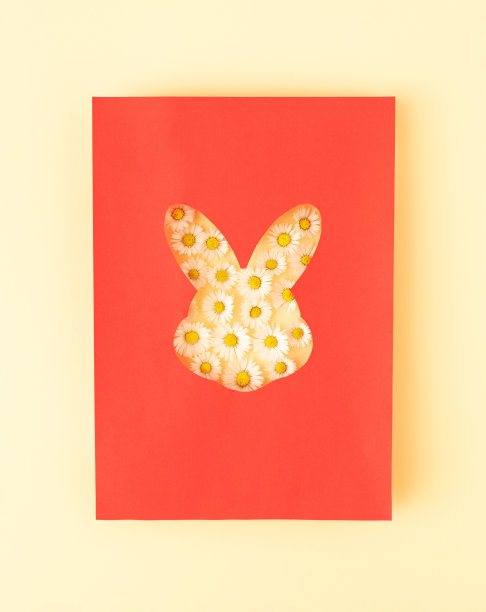 创意的想法，一个兔子形状的红纸与一束雏菊粉彩的背景。最小的复活节或春季概念与复制空间。前视图。图片下载
