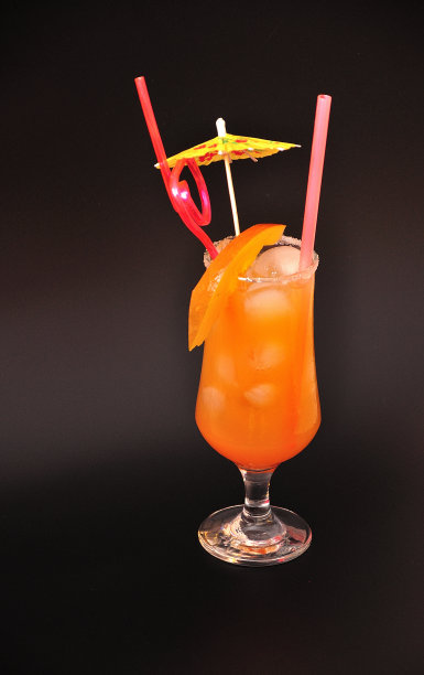 沙滩上的性爱，清爽的沙滩鸡尾酒在高脚杯里，黑色背景上有冰和吸管。图片下载