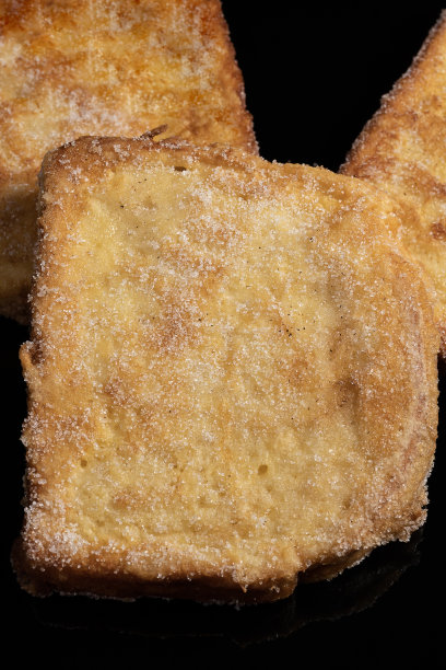 在牛奶中浸泡的面包，黑色背景上有香草、肉桂、柠檬和鸡蛋的味道。典型的复活节甜点。传统和节日美食的概念。图片下载