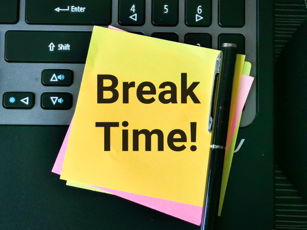 俯视图图片黄色便签写的文字休息时间用钢笔。图片下载