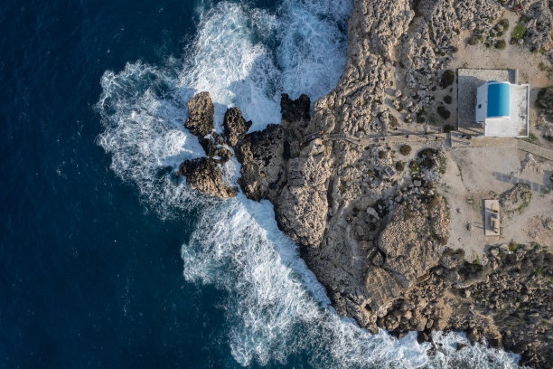 无人机航拍照片暴风雨多风的海浪撞击岩石海岸。图片下载