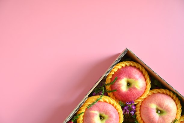 粉红色背景的盒子里有漂亮的苹果，健康的水果图片下载