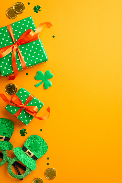圣帕特里克节的概念。俯视图垂直照片绿色礼盒与橙色蝴蝶结三叶草形状的五彩纸屑帽子形状的聚会眼镜和金币孤立的黄色背景与复制空间图片下载