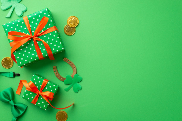 圣帕特里克节的概念。顶部视图照片绿色礼品盒与橙色丝带蝴蝶结金币马蹄铁领带蝴蝶结和三叶草在孤立的绿色背景与复制空间图片下载