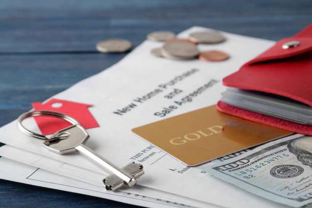 新房买卖协议。钥匙，钥匙圈，空白和钱在一个蓝色的木桌。买房的概念。图片下载