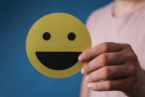 一个人举着黄色笑脸特写，企业招聘图片下载