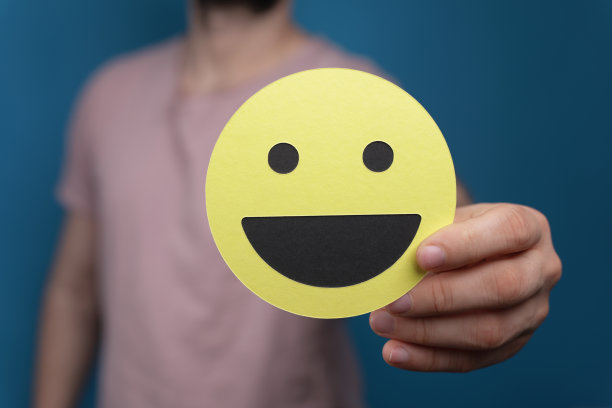 一个人举着黄色笑脸特写，企业招聘图片下载