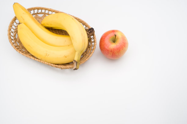 特写新鲜可口的有机香蕉与苹果在白色图片下载