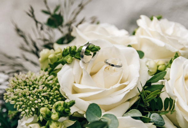 近距离选择焦点照片的结婚戒指上的白玫瑰花束。图片下载