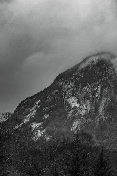 垂直拍摄陡峭的山峰，云层到达山顶图片下载