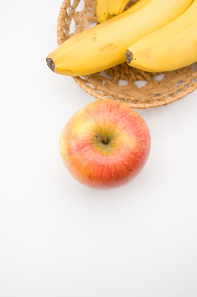特写新鲜可口的有机香蕉与苹果在白色图片下载