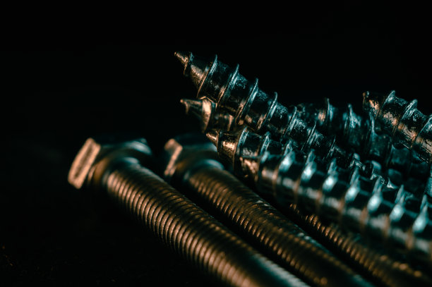 黑色背景上的一堆螺丝图片下载