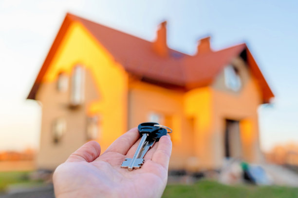 手拿钥匙在家门口。建筑，项目，搬到新家，抵押，租赁和购买房地产。图片下载