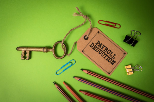 工资扣除。绿色办公桌上有价签的金钥匙图片下载