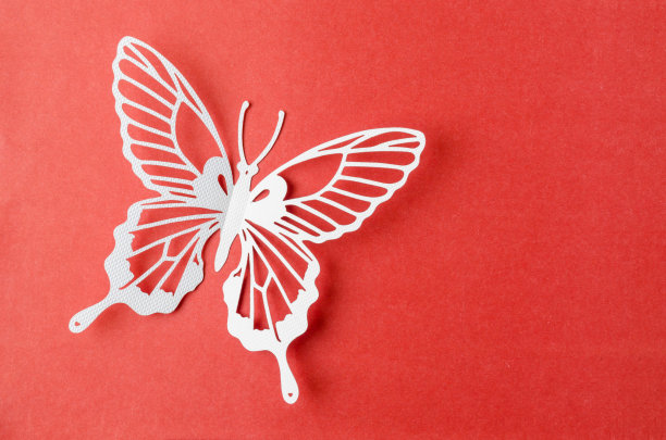 纸蝴蝶雕刻在一个红色的背景与空白。图片下载