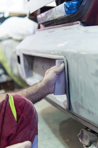 汽车修理工在车库里用手打磨汽车零件。以图片下载