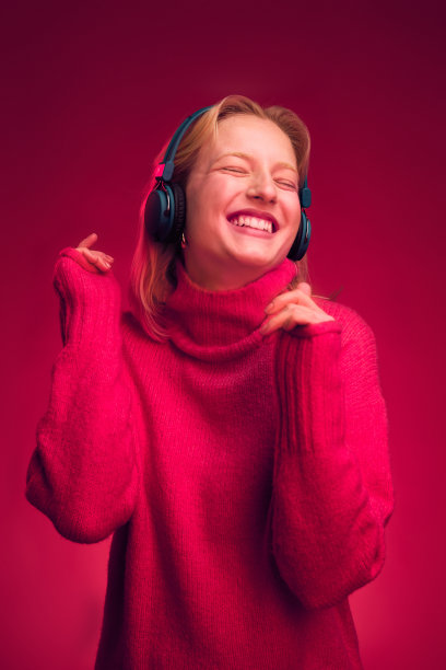一个快乐的女孩在品红的背景前跳舞，享受音乐。洋红色万岁。图片下载