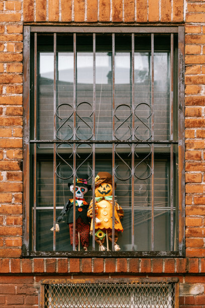 垂直拍摄的小万圣节玩具在窗玻璃图片下载