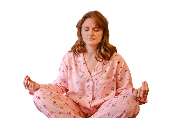 在冠状病毒感染期间，一名女子在白色背景上隔离的床上冥想。身穿粉色睡衣的女子在感染新冠流感病毒期间练习瑜伽，肖像图片下载