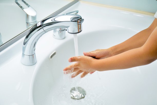 孩子在浴室的水龙头里洗手图片下载