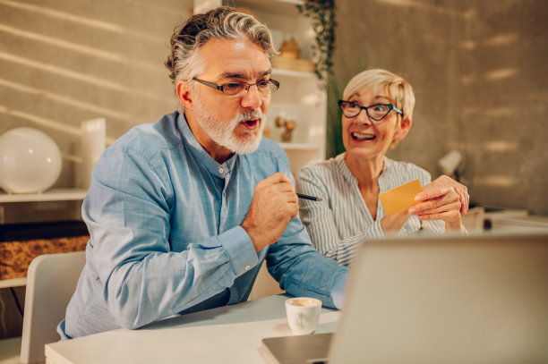一对老年夫妇在家用信用卡和笔记本电脑网购图片下载