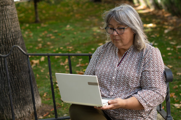 公园里一个拿着电脑的女人图片下载