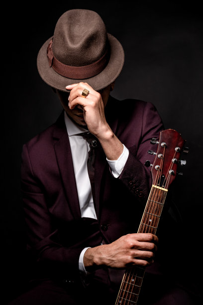来自西班牙的白人男子，穿着西装，手戴着帽子，拿着吉他图片下载