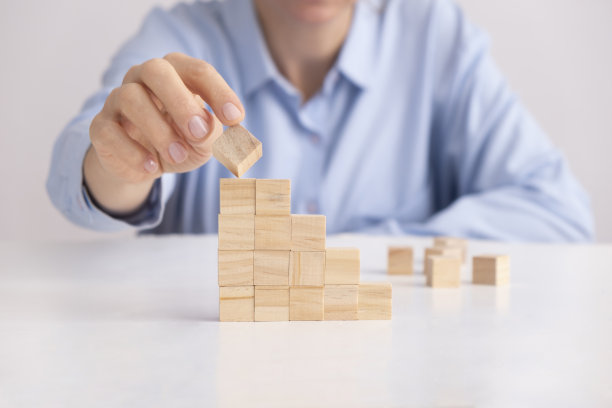 妇女安排木块堆叠作为阶梯或柱状图。图片下载