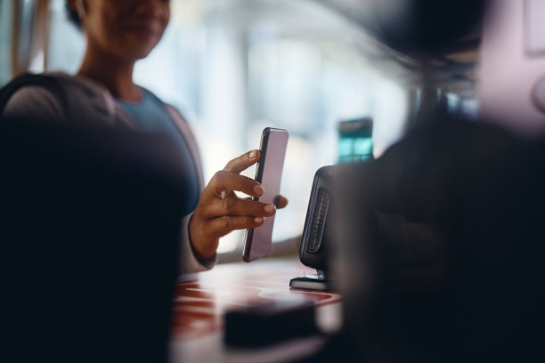 在健身房的前台用手机登记的女运动员的特写镜头。图片下载